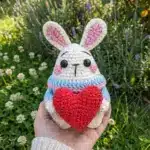 Bunny amigurumi free Valentine crochet pattern held in hand showing size of finished white bunny with red heart
