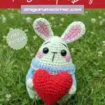 Handmade Valentine bunny amigurumi crochet pattern with red heart on outdoor stone surface in garden setting